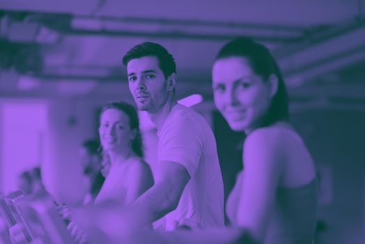 group of young people running on treadmills in modern sport  gym duo tone