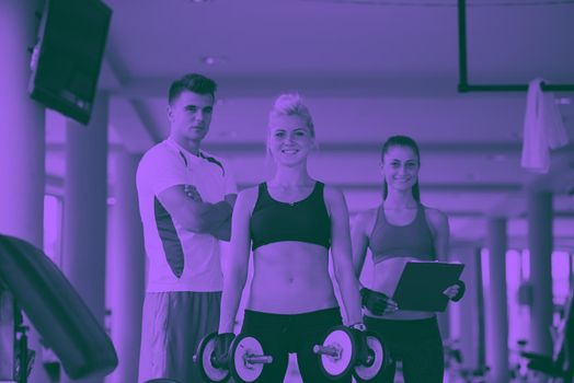 healthy and fit young woman in fitness gym lifting weights and working on her butt muscles duo tone