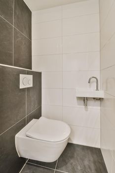 Superior washroom with wall hung toilet and black tiled floor