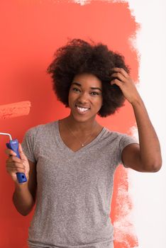 portrait of a young beautiful African American woman painting wall in her new apartment