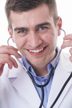 Coronavirus covid-19 pandemic Portrait of hero in white coat.  Cheerful smiling young doctor with stethoscope in medical hospital standing against white  background.