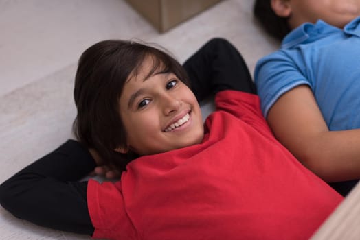 happy young boys having fun on the floor in a new modern home