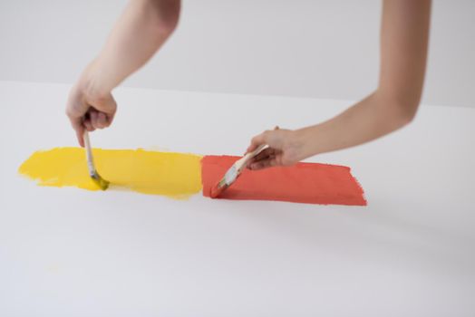 happy smiling young couple painting interior wall of new house