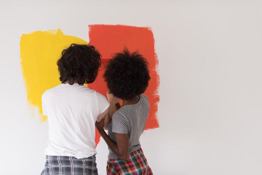 happy young multiethnic couple painting interior wall of new house