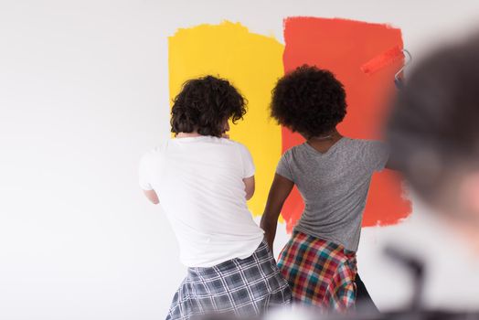 happy young multiethnic couple painting interior wall of new house