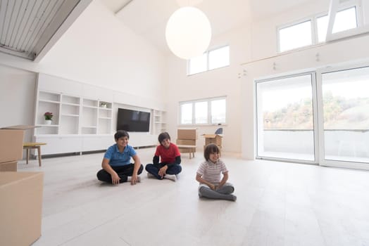 happy young boys having fun on the floor in a new modern home