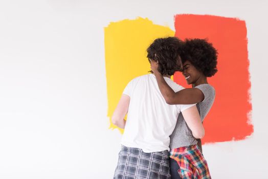 happy young multiethnic couple painting interior wall of new house