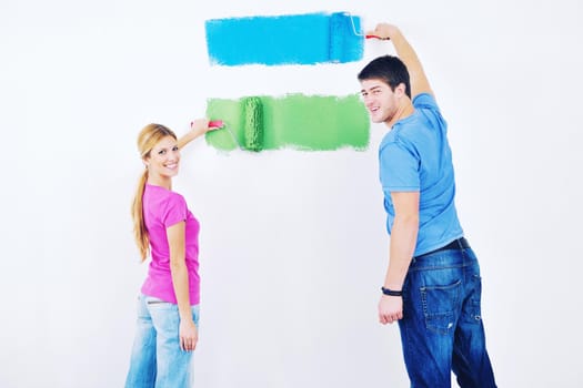 happy young couple paint in green and blue color white wall of their new home