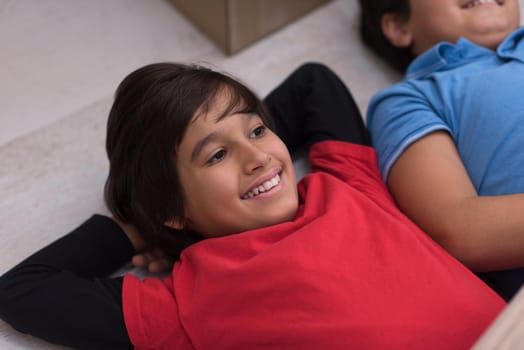 happy young boys having fun on the floor in a new modern home