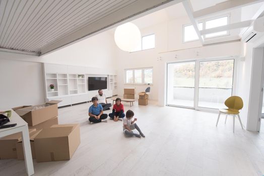 portrait of happy young boys with their dad sitting on the floor in a new modern home