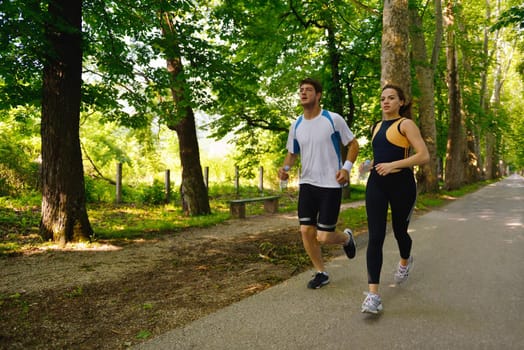 Young couple jogging in park at morning. Health and fitness.