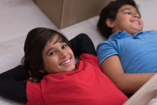 happy young boys having fun on the floor in a new modern home