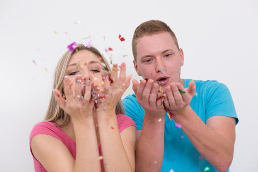 happy young romantic  couple in love  celebrating and blowing confetti decorations at new year and charismas  party