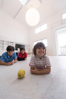 happy young boys having fun with an apple on the floor in a new modern home