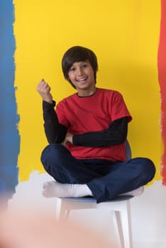 Portrait of a happy young boy in front of colored background