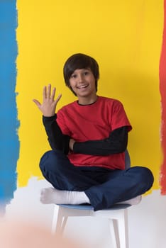 Portrait of a happy young boy in front of colored background