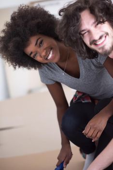 Portrait of a young multiethnic couple on a break from renovating their home