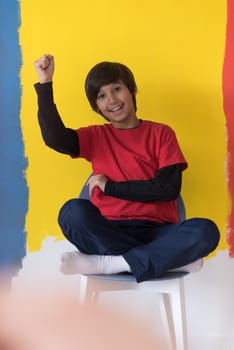 Portrait of a happy young boy in front of colored background