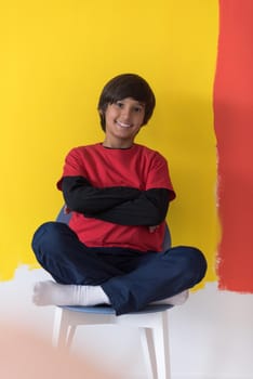 Portrait of a happy young boy in front of colored background