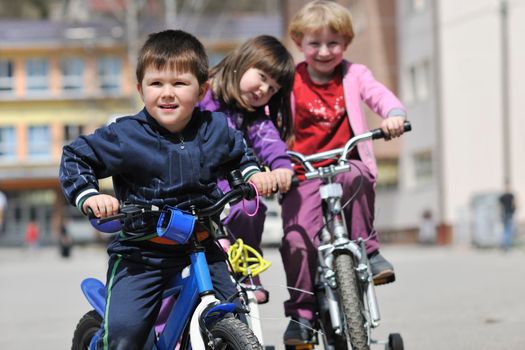 happy childrens group learning to drive bicycle outdoor at beautiful sunny spring day