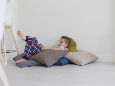 little boy playing video games on tablet computer at home