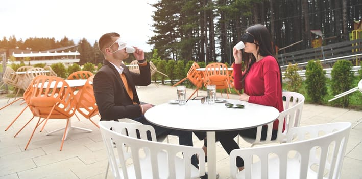 couple with protective medical mask  having coffee break in a restaurant, new normal coronavirus concept