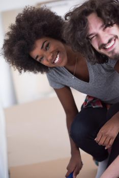 Portrait of a young multiethnic couple on a break from renovating their home