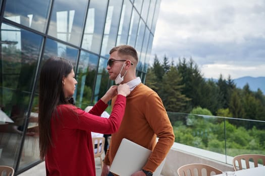 coronavirus outbreak Group of casual business People in outdoor restaurant wearing protective medical mask, business team collaborating and brainstorming business ideas  while working on laptop