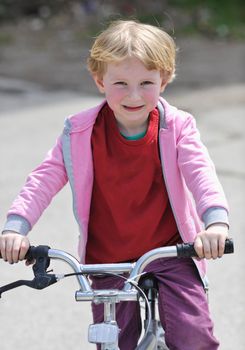 cute little girl learn to drive bicyle at sunny day 