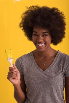 portrait of a young beautiful African American woman painting wall in her new apartment