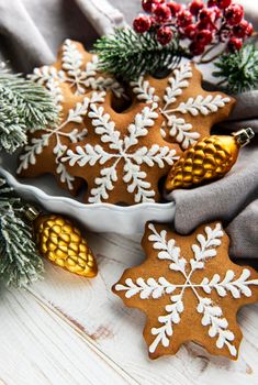 Bowl of gingerbread Christmas cookies on rustic white wooden table, and green fir branch. Copy space.