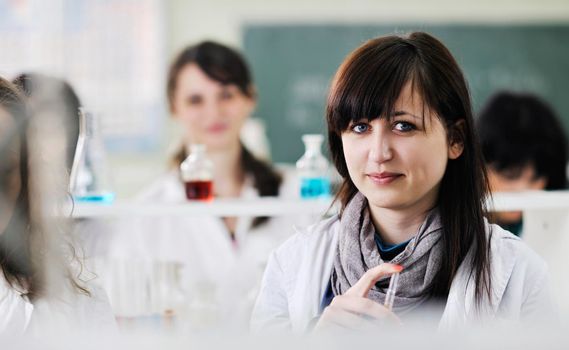 young woman students group in bright chemistry  lab