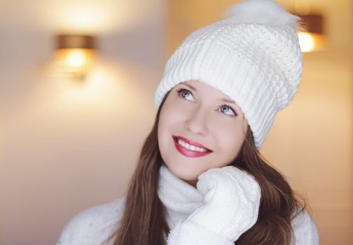 Christmas, people and winter holiday concept. Happy smiling woman wearing white knitted hat as closeup face xmas portrait.