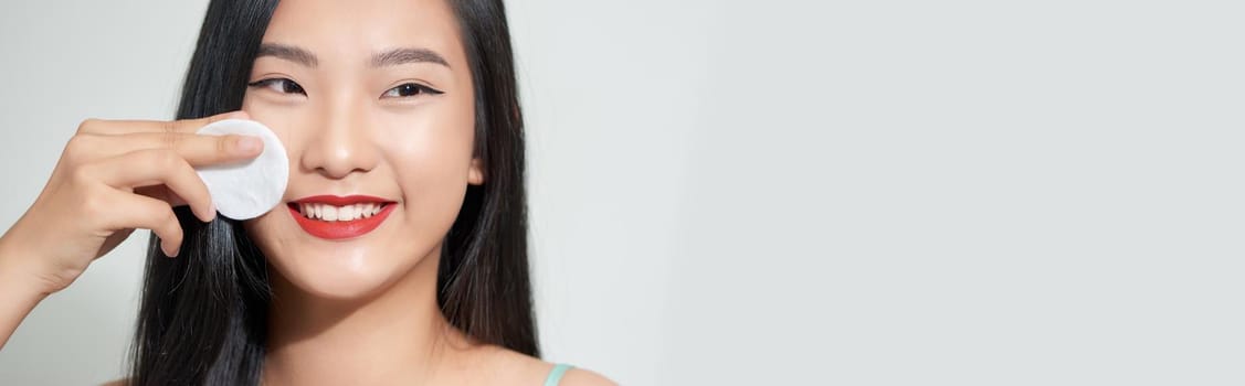 Portrait of a young beautiful woman using sponge, isolated on a white background