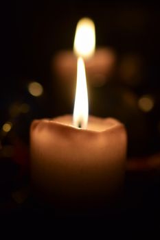 Burning beige candles as a close-up