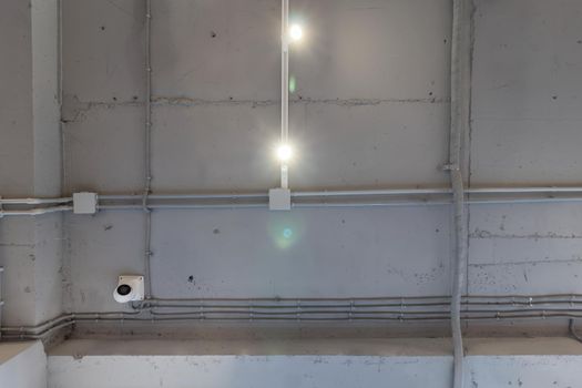 Interior architecture and ceiling design of industrial loft building decorated with modern lamps, glass windows and wall speakers