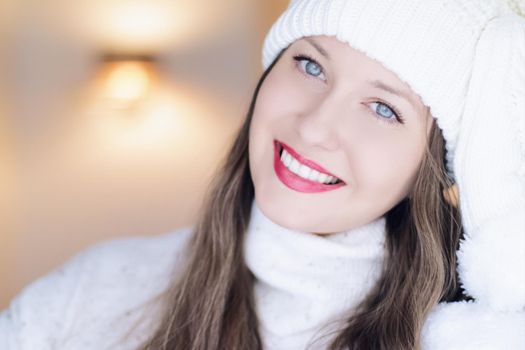 Christmas, people and winter holiday concept. Happy smiling woman wearing white knitted hat as closeup face xmas portrait.