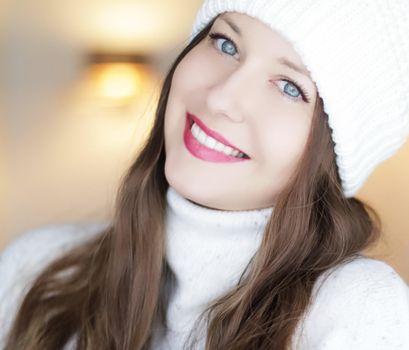 Christmas, people and winter holiday concept. Happy smiling woman wearing white knitted hat as closeup face xmas portrait.