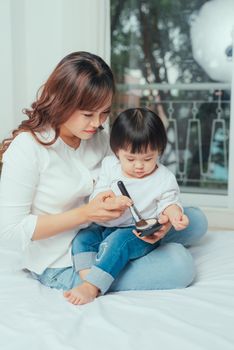 Young mother and her daughter spending time together in bedroom