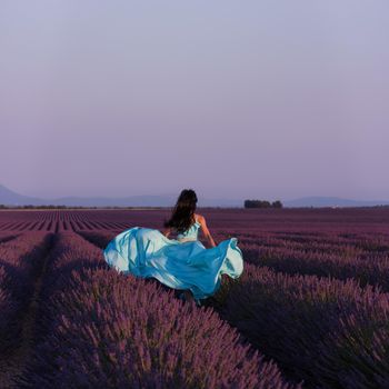 lavander flower field woman in cyand dress having fun and relax on wind in  purple flower field