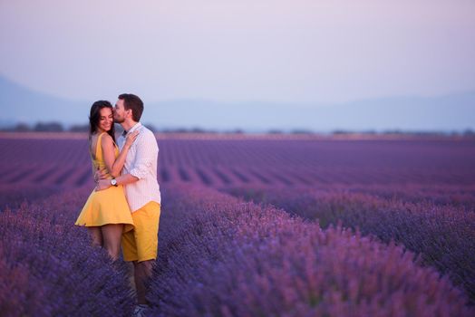 couple in purple lavender flower  field kissing and have romantic time in sunset