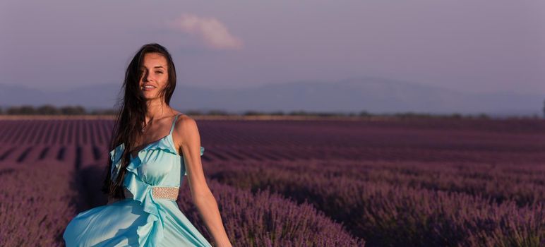 lavander flower field woman in cyand dress having fun and relax on wind in  purple flower field