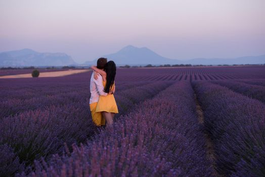 couple in purple lavender flower  field kissing and have romantic time in sunset