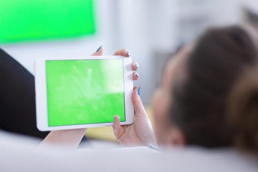 young happy woman on sofa using tablet computer at luxury home