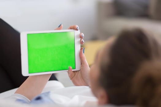 young happy woman on sofa using tablet computer at luxury home