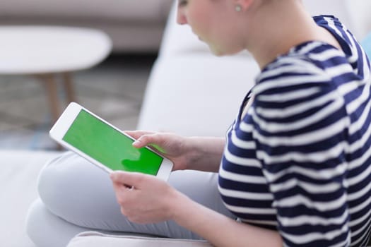 young happy woman on sofa using tablet computer at luxury home