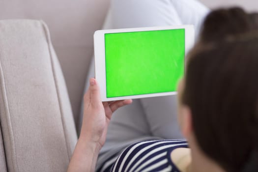 young happy woman on sofa using tablet computer at luxury home