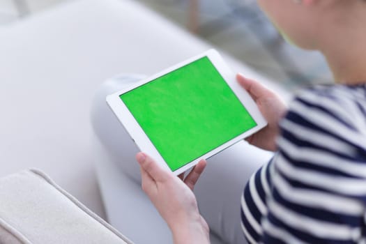 young happy woman on sofa using tablet computer at luxury home