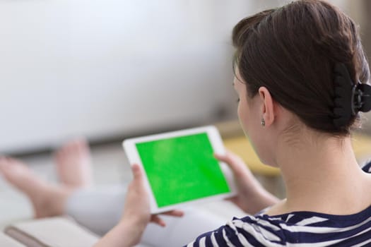 young happy woman on sofa using tablet computer at luxury home