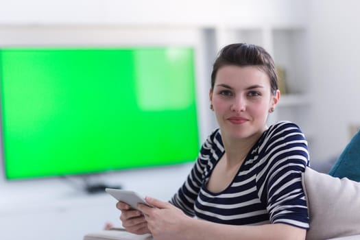 young happy woman on sofa using tablet computer at luxury home